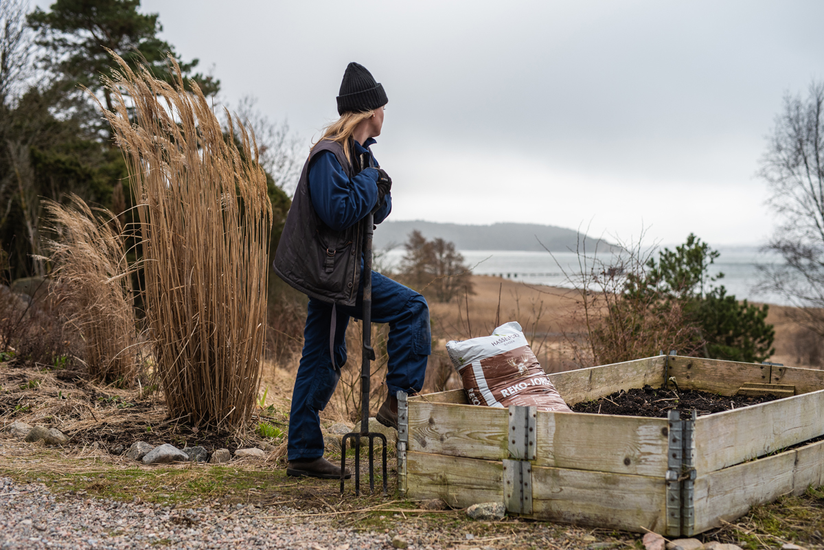 Emily står med grep bredvid en pallkrage, och tittar ut mot havet.